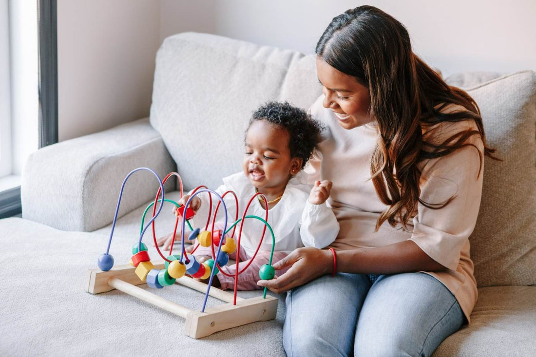 Infant activities for 6 to 12 month olds - mother helping baby with activity