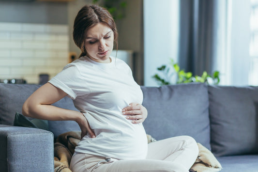 A pregnant woman looks uncomfortable