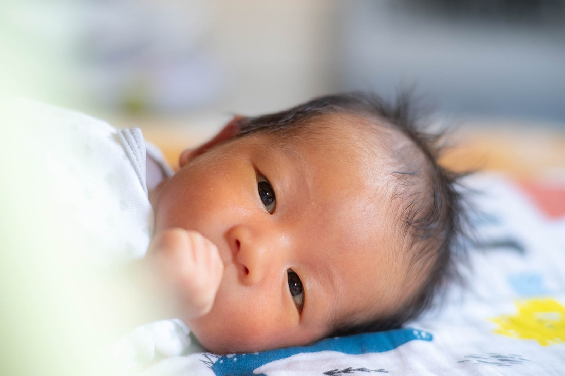 A newborn baby rests on their back