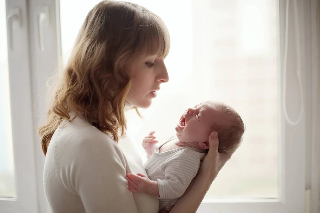 Mum soothing baby who won't sleep in bassinet