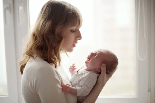 Mum soothing baby who won't sleep in bassinet