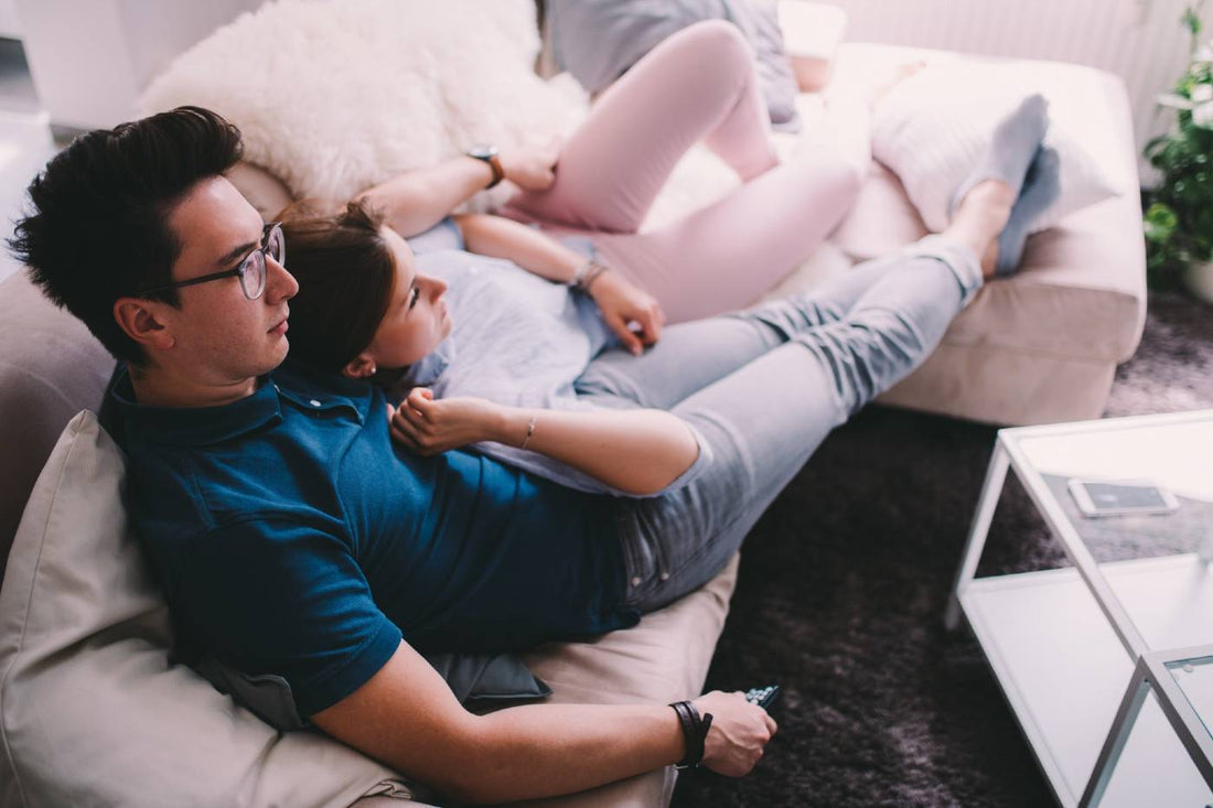Couple cuddling on the couch together.