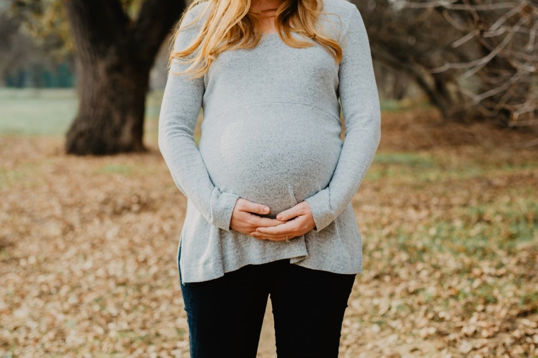 Pregnant woman cradles her belly
