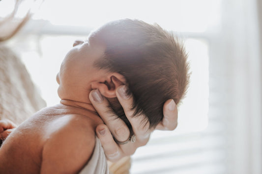 SNOO story - newborn baby being held by mom